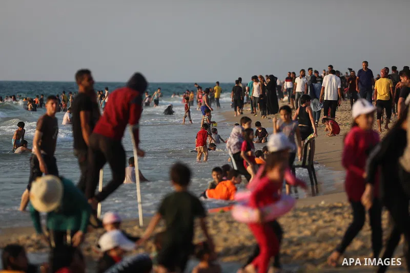 Palestinians enjoy the beach of the Mediterranean sea in Deir al-Balah in the center of Gaza Strip, on June 25, 2021. The beach is one of the few open public spaces in this densely populated city. Photo by Ashraf Amra