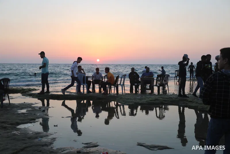 Palestinians enjoy the beach of the Mediterranean sea in Deir al-Balah in the center of Gaza Strip, on June 25, 2021. The beach is one of the few open public spaces in this densely populated city. Photo by Ashraf Amra