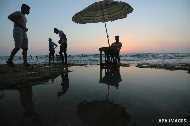 Palestinians enjoy the beach of the Mediterranean sea in Deir al-Balah in the center of Gaza Strip, on June 25, 2021. The beach is one of the few open public spaces in this densely populated city. Photo by Ashraf Amra