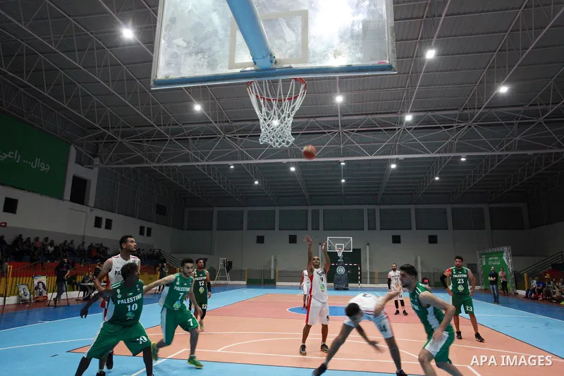 Palestinian basketball players of Khadamat al-Burij club (whiteT-shirt) and khadamat Rafah (greenT-shirt) compete during a super Cup, in Gaza City on June 25, 2021. Photo by Ali Hamad