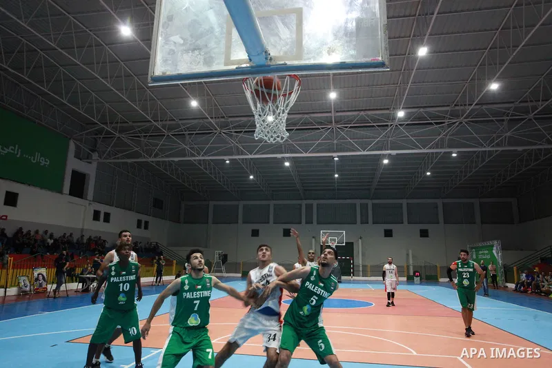Palestinian basketball players of Khadamat al-Burij club (whiteT-shirt) and khadamat Rafah (greenT-shirt) compete during a super Cup, in Gaza City on June 25, 2021. Photo by Ali Hamad