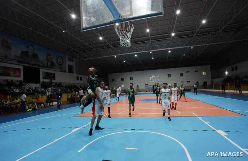 Palestinian basketball players of Khadamat al-Burij club (whiteT-shirt) and khadamat Rafah (greenT-shirt) compete during a super Cup, in Gaza City on June 25, 2021. Photo by Ali Hamad