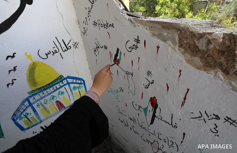 Palestinian artist Saja Moussa draws on broken tiles from her family's house in Rafah refugee camp, southern Gaza Strip, on June 26, 2021. The house was damaged last month during an 11-day war between Israel and the Hama...