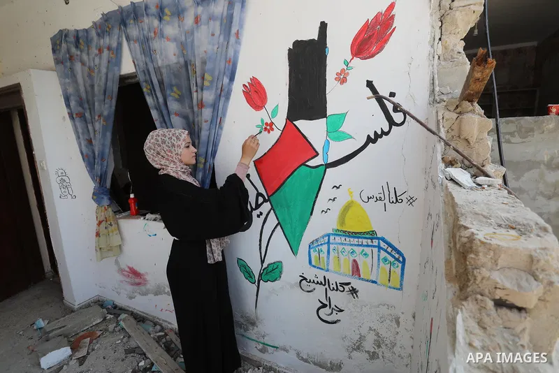 Palestinian artist Saja Moussa draws on broken tiles from her family's house in Rafah refugee camp, southern Gaza Strip, on June 26, 2021. The house was damaged last month during an 11-day war between Israel and the Hama...