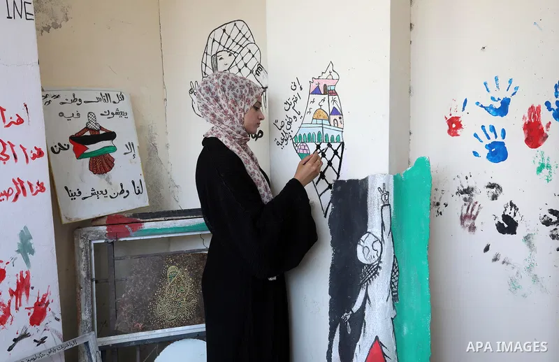 Palestinian artist Saja Moussa draws on broken tiles from her family's house in Rafah refugee camp, southern Gaza Strip, on June 26, 2021. The house was damaged last month during an 11-day war between Israel and the Hama...