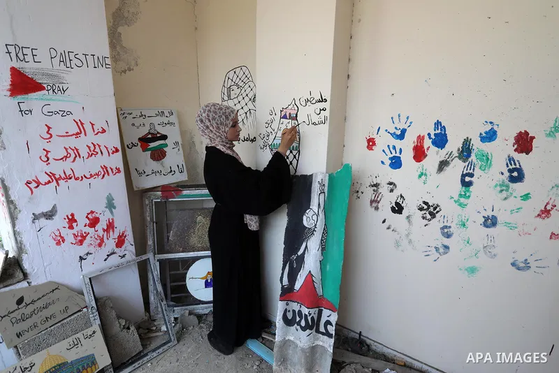 Palestinian artist Saja Moussa draws on broken tiles from her family's house in Rafah refugee camp, southern Gaza Strip, on June 26, 2021. The house was damaged last month during an 11-day war between Israel and the Hama...