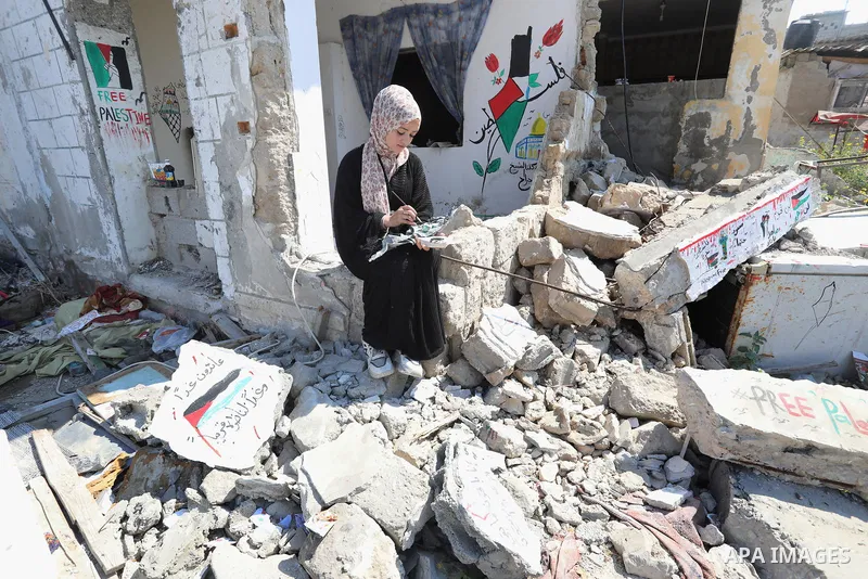 Palestinian artist Saja Moussa draws on broken tiles from her family's house in Rafah refugee camp, southern Gaza Strip, on June 26, 2021. The house was damaged last month during an 11-day war between Israel and the Hama...