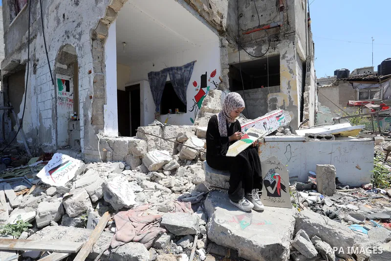 Palestinian artist Saja Moussa draws on broken tiles from her family's house in Rafah refugee camp, southern Gaza Strip, on June 26, 2021. The house was damaged last month during an 11-day war between Israel and the Hama...