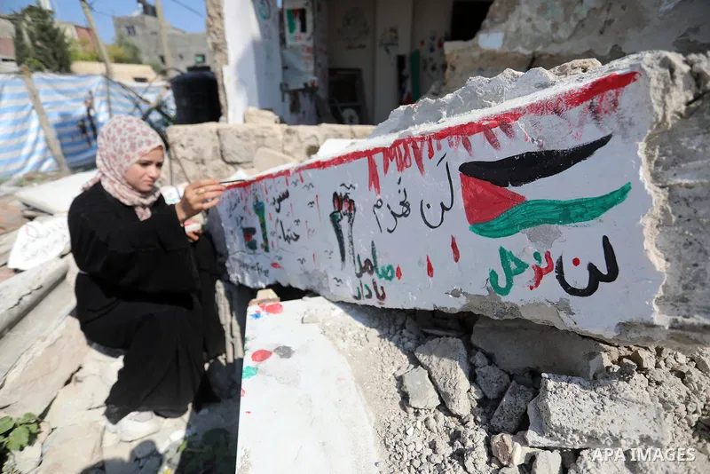 Palestinian artist Saja Moussa draws on broken tiles from her family's house in Rafah refugee camp, southern Gaza Strip, on June 26, 2021. The house was damaged last month during an 11-day war between Israel and the Hama...