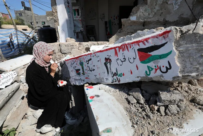 Palestinian artist Saja Moussa draws on broken tiles from her family's house in Rafah refugee camp, southern Gaza Strip, on June 26, 2021. The house was damaged last month during an 11-day war between Israel and the Hama...