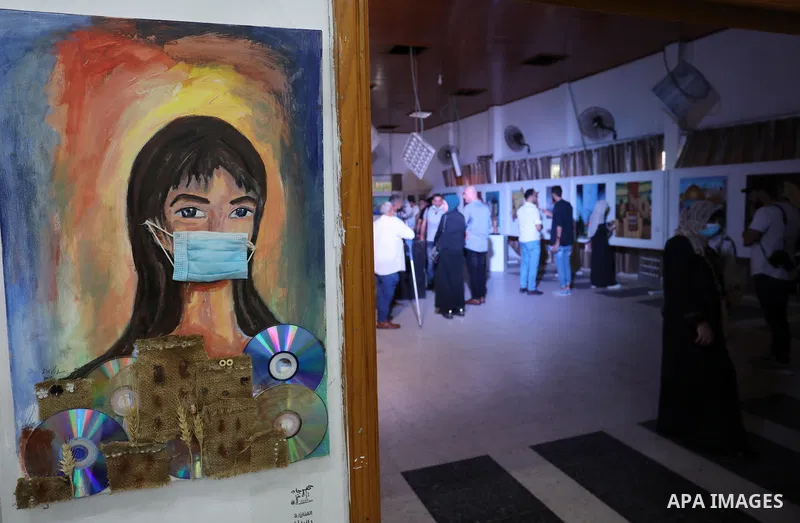 Palestinians attend an exhibition of paintings and sculptures, organized by the Gaza Center for Culture and Arts Association "The Third Gaza Contemporary Visual Arts Festival 2021" in Gaza City, on June 28, 2021. Photo b...