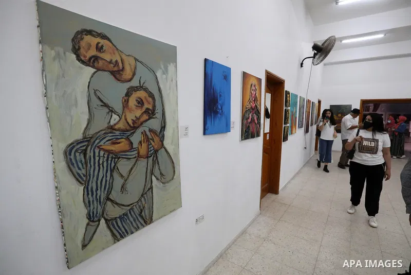 Palestinians attend an exhibition of paintings and sculptures, organized by the Gaza Center for Culture and Arts Association "The Third Gaza Contemporary Visual Arts Festival 2021" in Gaza City, on June 28, 2021. Photo b...