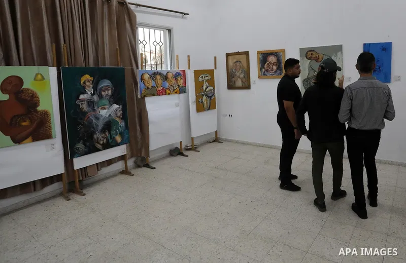 Palestinians attend an exhibition of paintings and sculptures, organized by the Gaza Center for Culture and Arts Association "The Third Gaza Contemporary Visual Arts Festival 2021" in Gaza City, on June 28, 2021. Photo b...