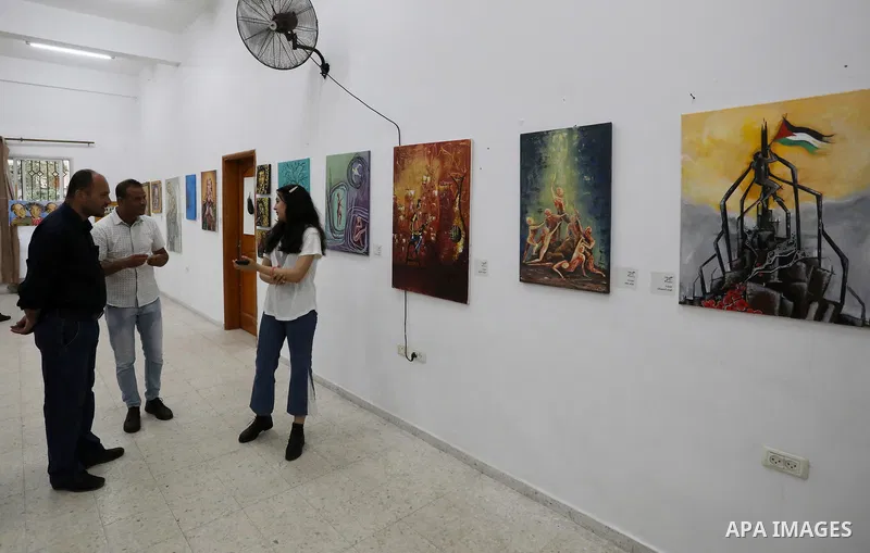 Palestinians attend an exhibition of paintings and sculptures, organized by the Gaza Center for Culture and Arts Association "The Third Gaza Contemporary Visual Arts Festival 2021" in Gaza City, on June 28, 2021. Photo b...