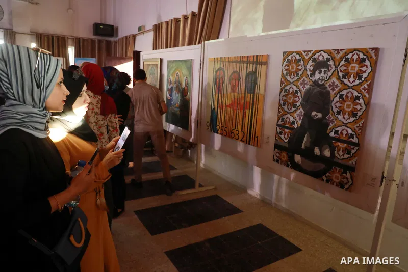 Palestinians attend an exhibition of paintings and sculptures, organized by the Gaza Center for Culture and Arts Association "The Third Gaza Contemporary Visual Arts Festival 2021" in Gaza City, on June 28, 2021. Photo b...