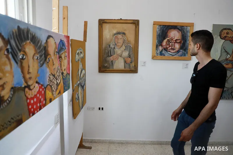 Palestinians attend an exhibition of paintings and sculptures, organized by the Gaza Center for Culture and Arts Association "The Third Gaza Contemporary Visual Arts Festival 2021" in Gaza City, on June 28, 2021. Photo b...