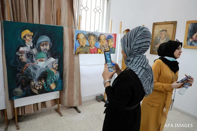 Palestinians attend an exhibition of paintings and sculptures, organized by the Gaza Center for Culture and Arts Association "The Third Gaza Contemporary Visual Arts Festival 2021" in Gaza City, on June 28, 2021. Photo b...
