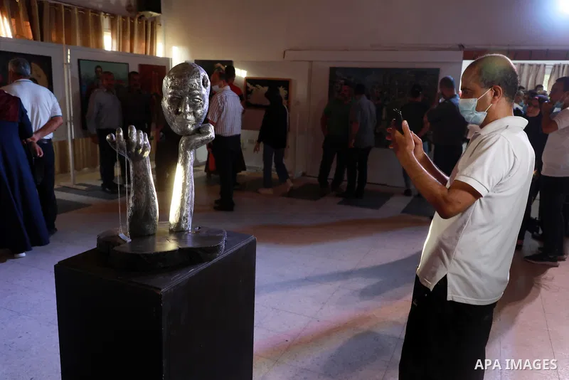 Palestinians attend an exhibition of paintings and sculptures, organized by the Gaza Center for Culture and Arts Association "The Third Gaza Contemporary Visual Arts Festival 2021" in Gaza City, on June 28, 2021. Photo b...