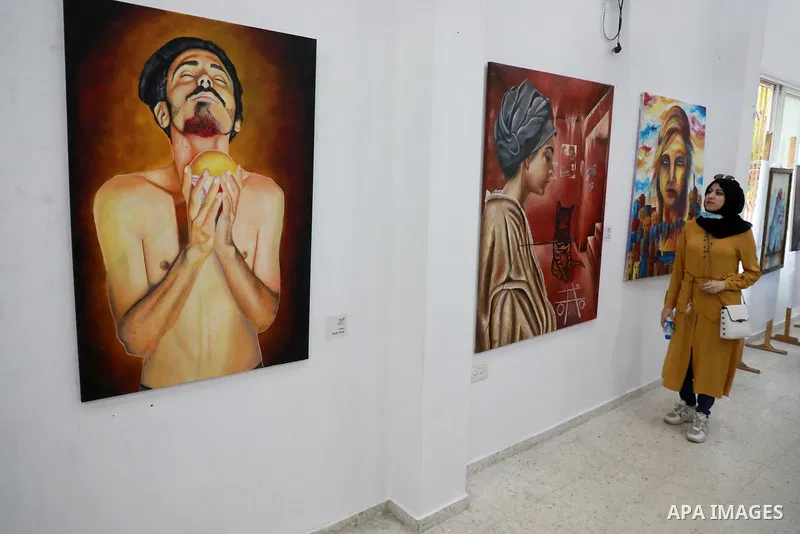 Palestinians attend an exhibition of paintings and sculptures, organized by the Gaza Center for Culture and Arts Association "The Third Gaza Contemporary Visual Arts Festival 2021" in Gaza City, on June 28, 2021. Photo b...