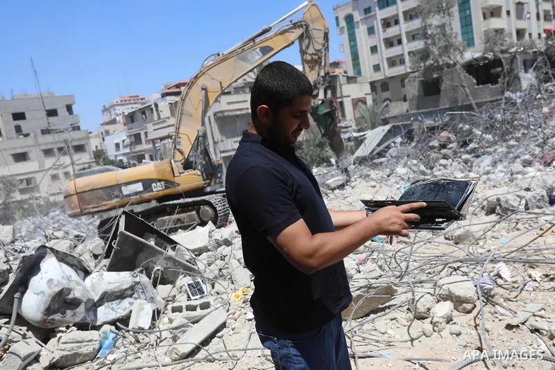 Palestinian engineer Ahmed Al-Qiq, 30, inspects damage at his center for the Training and Development, which was destroyed by Israeli air strikes during the May 2021 conflict between Hamas and Israel, in Gaza city, on Ju...
