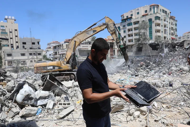 Palestinian engineer Ahmed Al-Qiq, 30, inspects damage at his center for the Training and Development, which was destroyed by Israeli air strikes during the May 2021 conflict between Hamas and Israel, in Gaza city, on Ju...