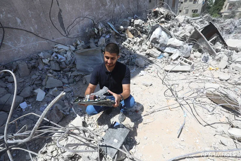 Palestinian engineer Ahmed Al-Qiq, 30, inspects damage at his center for the Training and Development, which was destroyed by Israeli air strikes during the May 2021 conflict between Hamas and Israel, in Gaza city, on Ju...