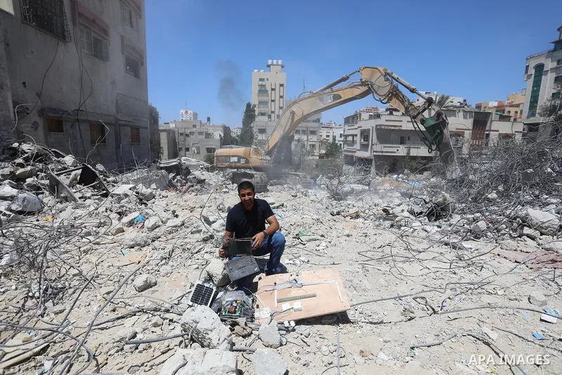 Palestinian engineer Ahmed Al-Qiq, 30, inspects damage at his center for the Training and Development, which was destroyed by Israeli air strikes during the May 2021 conflict between Hamas and Israel, in Gaza city, on Ju...