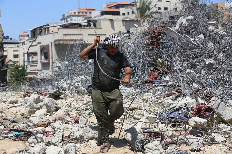 Palestinian engineer Ahmed Al-Qiq, 30, inspects damage at his center for the Training and Development, which was destroyed by Israeli air strikes during the May 2021 conflict between Hamas and Israel, in Gaza city, on Ju...