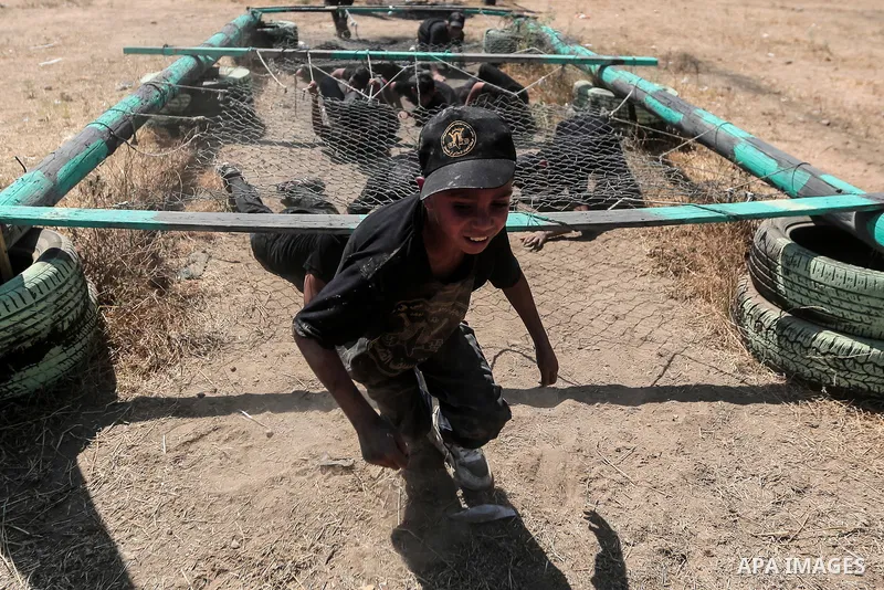 Young Palestinians attend a military summer camp organised by the Islamic Jihad Movement, in Gaza City, June 29, 2021. Photo by Mohammed Dahman Young Palestinians attend a military summer camp organised by the Islamic Ji...