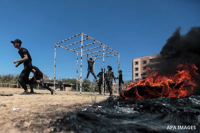 Young Palestinians attend a military summer camp organised by the Islamic Jihad Movement, in Gaza City, June 29, 2021. Photo by Mohammed Dahman Young Palestinians attend a military summer camp organised by the Islamic Ji...