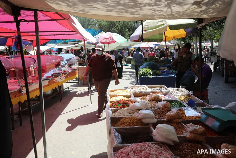 . Photo by Ashraf Amra Palestinians shop at a weekly market in Deir al-Balah in the center of Gaza Strip on June 29, 2021. The authorities in Gaza Strip decided to reopen the popular markets, after its closure, due to th...