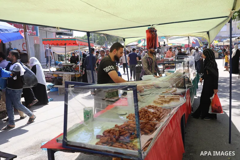 . Photo by Ashraf Amra Palestinians shop at a weekly market in Deir al-Balah in the center of Gaza Strip on June 29, 2021. The authorities in Gaza Strip decided to reopen the popular markets, after its closure, due to th...