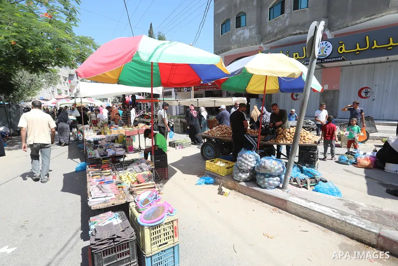 . Photo by Ashraf Amra Palestinians shop at a weekly market in Deir al-Balah in the center of Gaza Strip on June 29, 2021. The authorities in Gaza Strip decided to reopen the popular markets, after its closure, due to th...