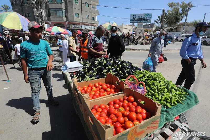 . Photo by Ashraf Amra Palestinians shop at a weekly market in Deir al-Balah in the center of Gaza Strip on June 29, 2021. The authorities in Gaza Strip decided to reopen the popular markets, after its closure, due to th...