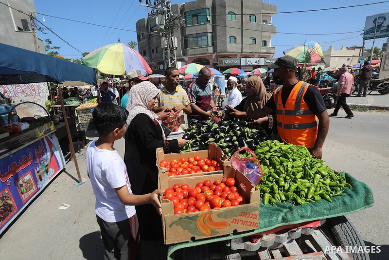 . Photo by Ashraf Amra Palestinians shop at a weekly market in Deir al-Balah in the center of Gaza Strip on June 29, 2021. The authorities in Gaza Strip decided to reopen the popular markets, after its closure, due to th...