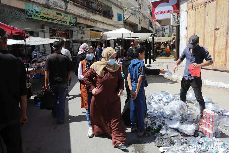 . Photo by Ashraf Amra Palestinians shop at a weekly market in Deir al-Balah in the center of Gaza Strip on June 29, 2021. The authorities in Gaza Strip decided to reopen the popular markets, after its closure, due to th...