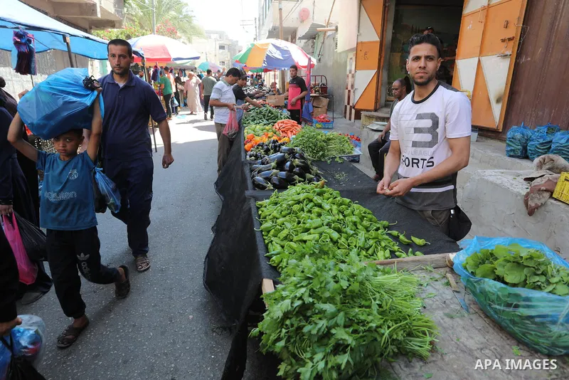 . Photo by Ashraf Amra Palestinians shop at a weekly market in Deir al-Balah in the center of Gaza Strip on June 29, 2021. The authorities in Gaza Strip decided to reopen the popular markets, after its closure, due to th...