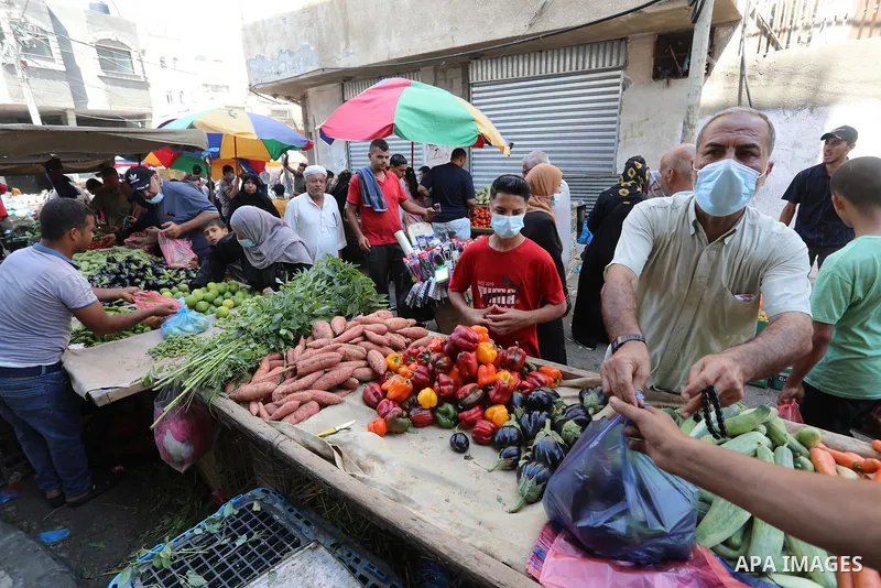 . Photo by Ashraf Amra Palestinians shop at a weekly market in Deir al-Balah in the center of Gaza Strip on June 29, 2021. The authorities in Gaza Strip decided to reopen the popular markets, after its closure, due to th...