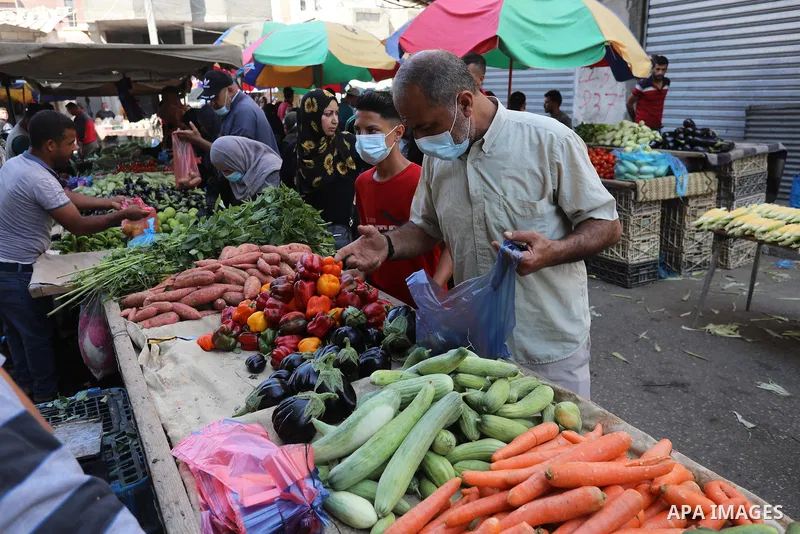 . Photo by Ashraf Amra Palestinians shop at a weekly market in Deir al-Balah in the center of Gaza Strip on June 29, 2021. The authorities in Gaza Strip decided to reopen the popular markets, after its closure, due to th...