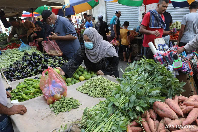 . Photo by Ashraf Amra Palestinians shop at a weekly market in Deir al-Balah in the center of Gaza Strip on June 29, 2021. The authorities in Gaza Strip decided to reopen the popular markets, after its closure, due to th...