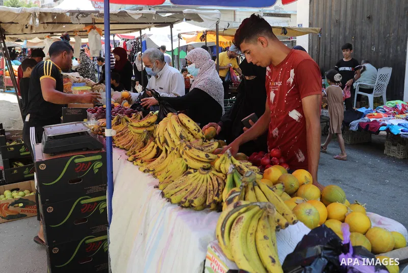 . Photo by Ashraf Amra Palestinians shop at a weekly market in Deir al-Balah in the center of Gaza Strip on June 29, 2021. The authorities in Gaza Strip decided to reopen the popular markets, after its closure, due to th...