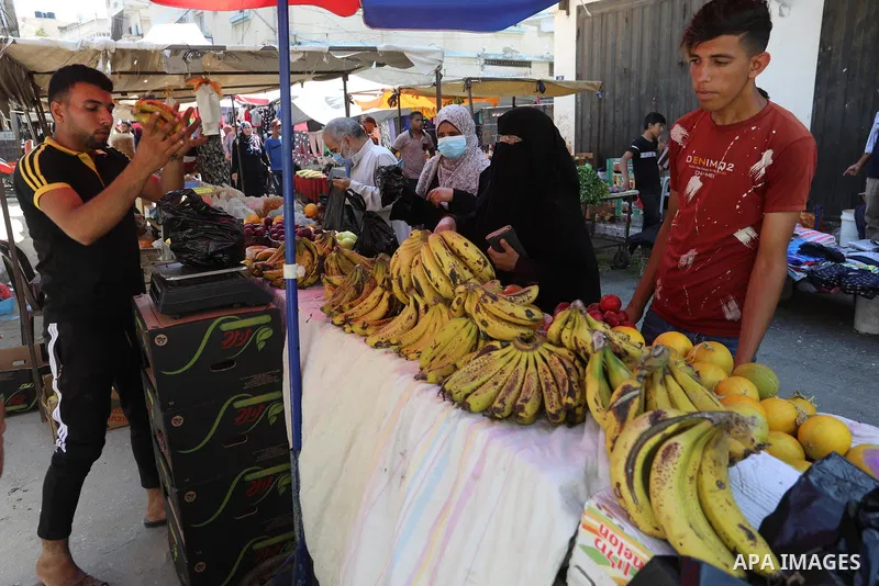 . Photo by Ashraf Amra Palestinians shop at a weekly market in Deir al-Balah in the center of Gaza Strip on June 29, 2021. The authorities in Gaza Strip decided to reopen the popular markets, after its closure, due to th...
