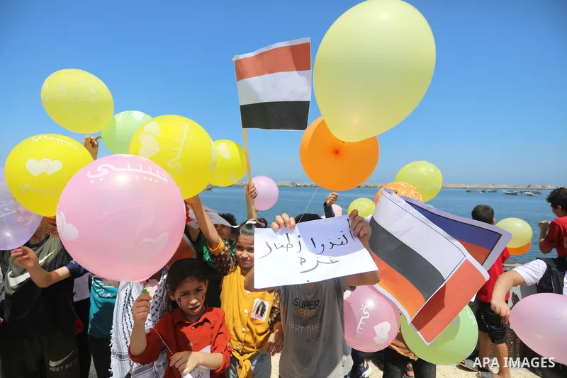 Palestinian children hold helium balloons as they take part in a rally, in the Gaza port, on June 30, 2021. Children from Gaza send messages to the countries of the world, expressing their wishes and aspirations to respe...