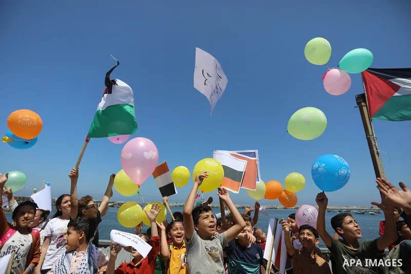 Palestinian children hold helium balloons as they take part in a rally, in the Gaza port, on June 30, 2021. Children from Gaza send messages to the countries of the world, expressing their wishes and aspirations to respe...