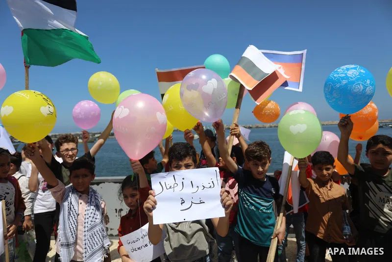 Palestinian children hold helium balloons as they take part in a rally, in the Gaza port, on June 30, 2021. Children from Gaza send messages to the countries of the world, expressing their wishes and aspirations to respe...