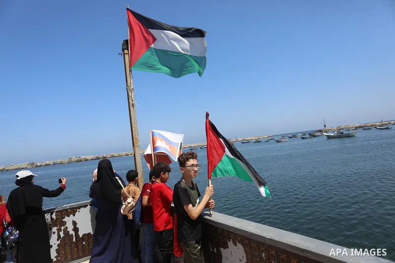 Palestinian children hold helium balloons as they take part in a rally, in the Gaza port, on June 30, 2021. Children from Gaza send messages to the countries of the world, expressing their wishes and aspirations to respe...