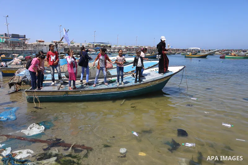 Palestinian children hold helium balloons as they take part in a rally, in the Gaza port, on June 30, 2021. Children from Gaza send messages to the countries of the world, expressing their wishes and aspirations to respe...