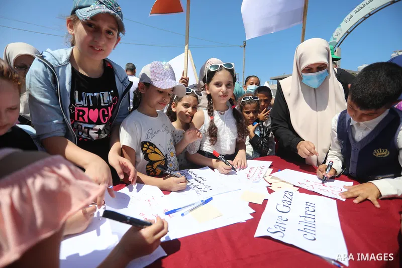 Palestinian children hold helium balloons as they take part in a rally, in the Gaza port, on June 30, 2021. Children from Gaza send messages to the countries of the world, expressing their wishes and aspirations to respe...