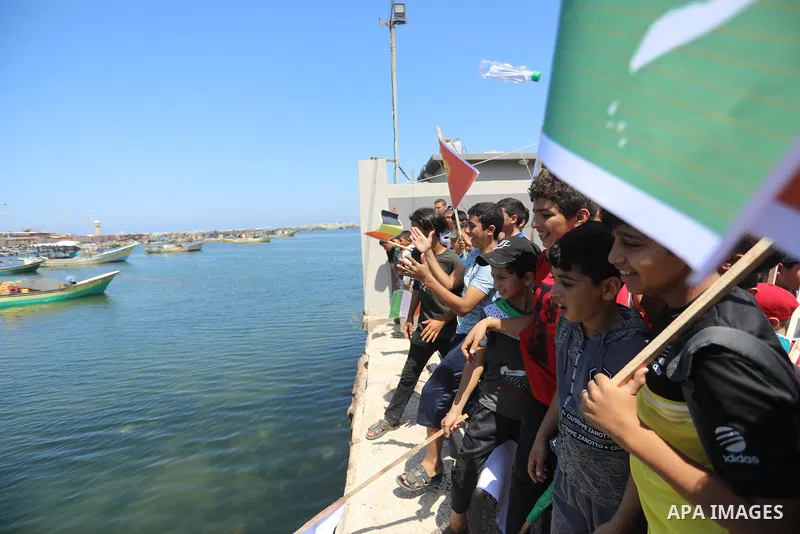 Palestinian children hold helium balloons as they take part in a rally, in the Gaza port, on June 30, 2021. Children from Gaza send messages to the countries of the world, expressing their wishes and aspirations to respe...