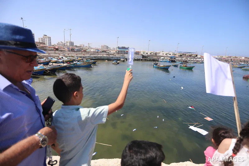 Palestinian children hold helium balloons as they take part in a rally, in the Gaza port, on June 30, 2021. Children from Gaza send messages to the countries of the world, expressing their wishes and aspirations to respe...